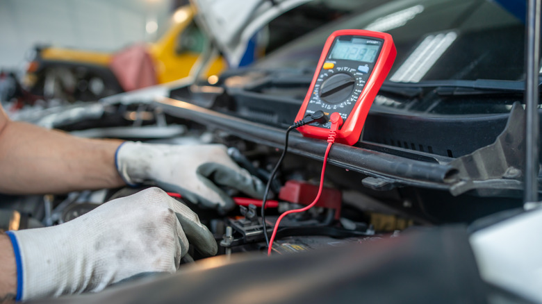 Mechanic testing car battery