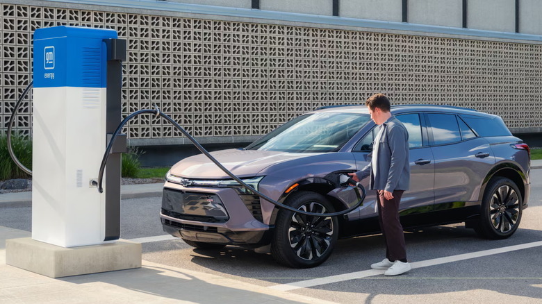 man using public EV charging station to charge a 2024 Chevrolet Blazer EV