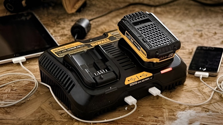 DeWalt dual battery charger powering a battery, phone, and tablet