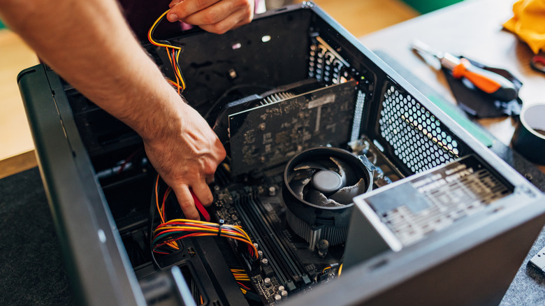 A person repairing the components inside a PC case