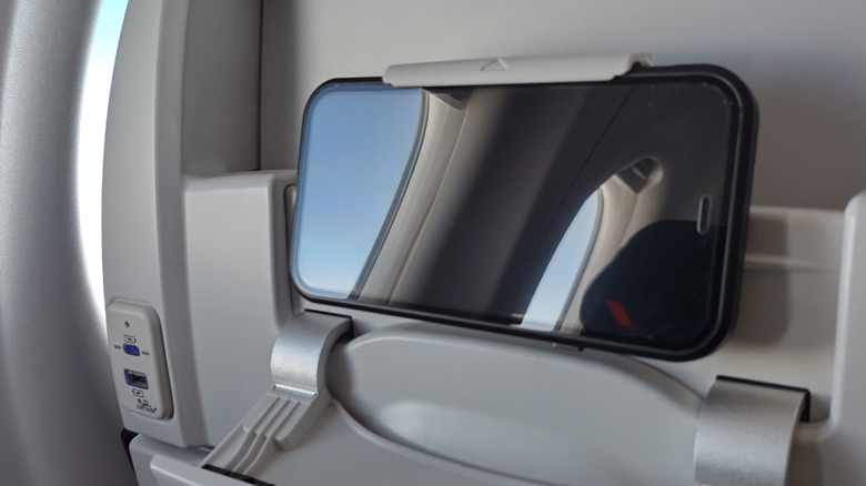Mobile phone in airplane seat backrest holder