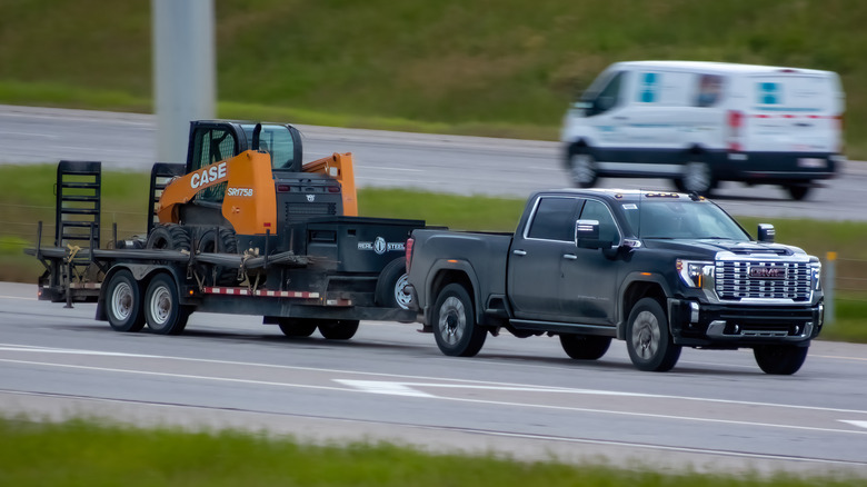 Pickup truck towing construction equipment on the highway