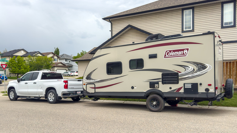 Truck with an RV being towed behind on suburban street