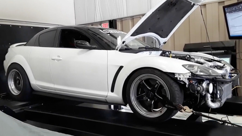Side profile view of a white LS-swapped Mazda RX-8 on a dyno