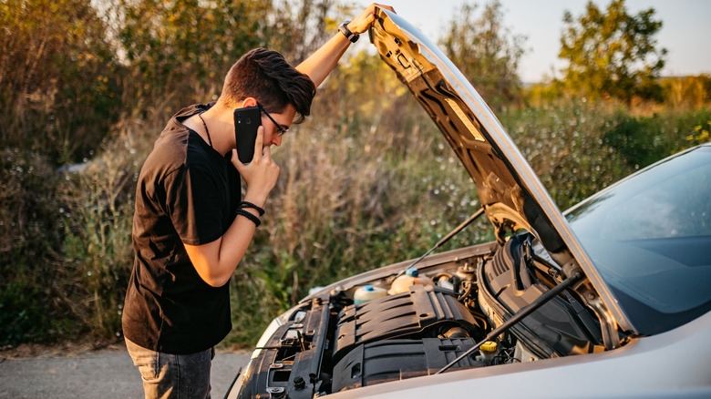 Young man with a car that has a breakdown