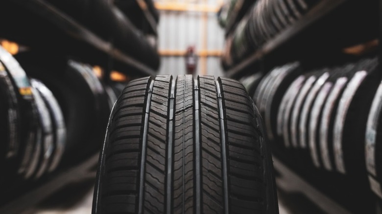an image of a new tire in the middle of a row of shelves of new tires