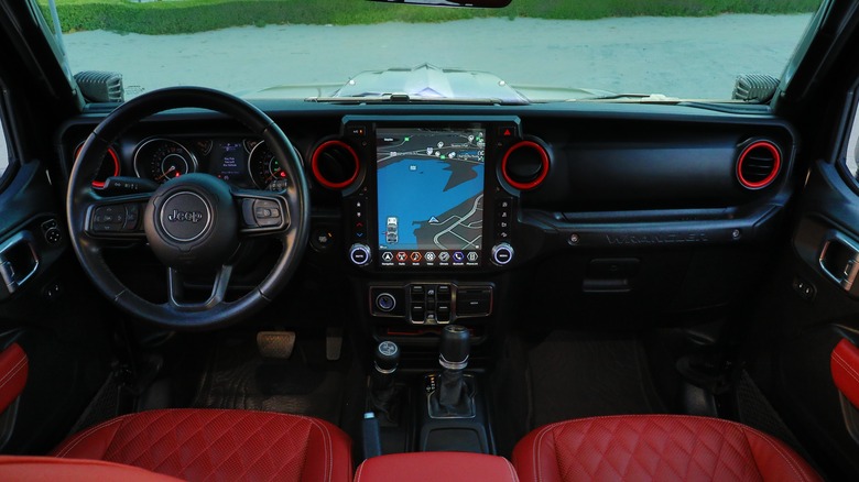 The interior of a Jeep with red leather seats and accents.