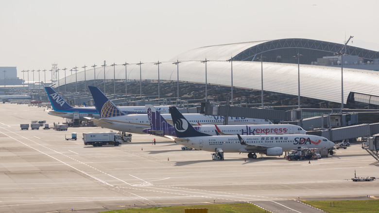 Lineup of aircraft at gates of Kansai International Airport terminal, right-side view