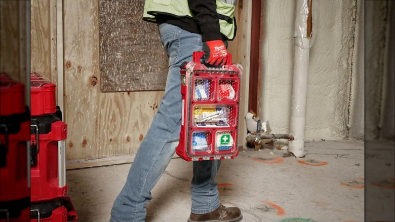 Worker carrying Milwaukee 79-piece Packout First Aid Kit