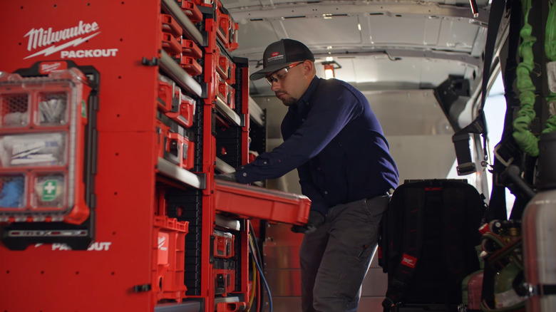 Person pulling out container from a Milwaukee Packout Rack Kit