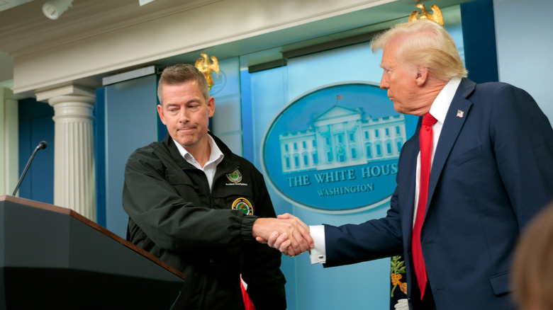 President Trump and Secretary Duffy shake hands during a White House press briefing.