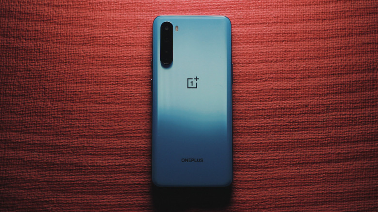 Blue OnePlus phone on a red crafting paper