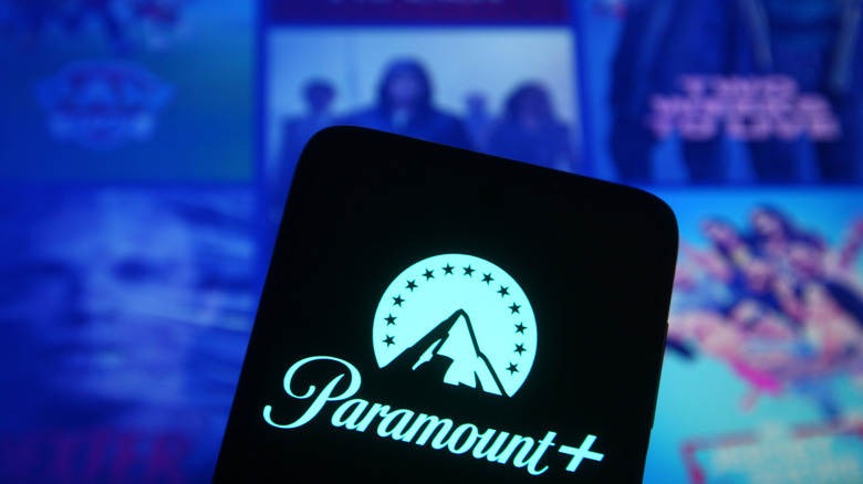 Smartphone with Paramount Plus logo in front of screen with various titles