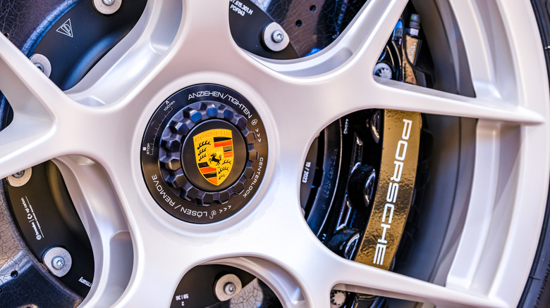 Close-up of car wheel showing Porsche logo and Porsche-branded brake caliper