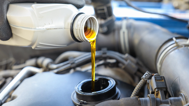 Man pouring motor oil in an engine
