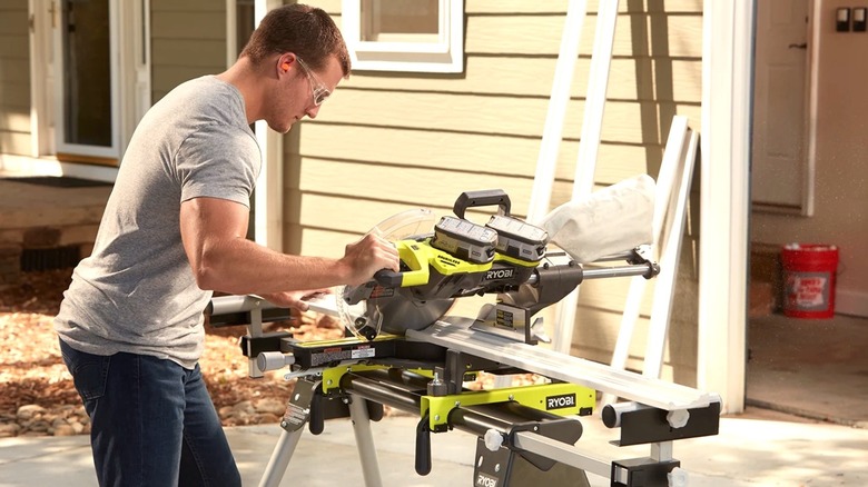 Person using miter saw to cut wood on the Ryobi quickstand