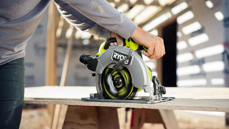 A person using a Ryobi ONE+ circular saw