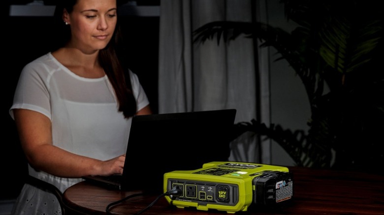 Ryobi 800-Watt Power Inverter powering woman's laptop