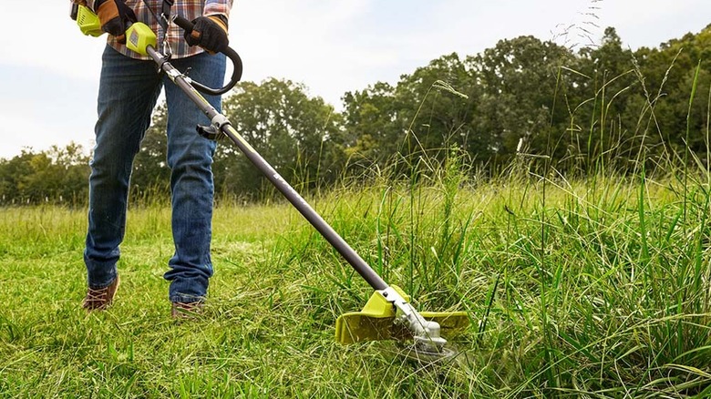man using Ryobi brush cutter attachment