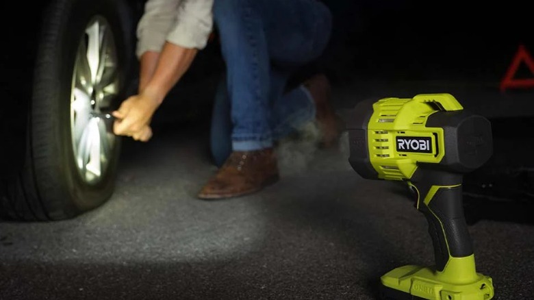 Ryobi Spotlight aimed at person changing tire