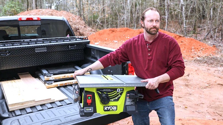 Person carrying Ryobi Table Saw
