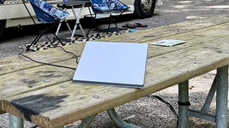 A Starlink Mini on a picnic table at a campground