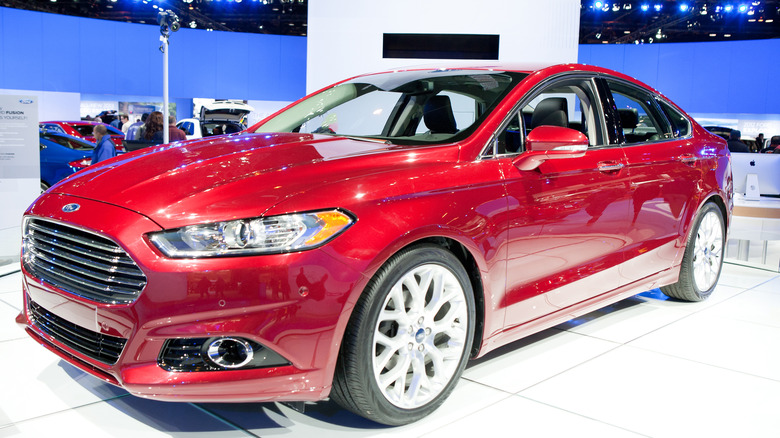 A red 2013 Ford Fusion on display at an auto show