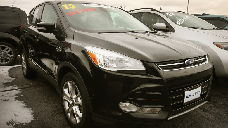 A black 2013 Ford Escape in a lot