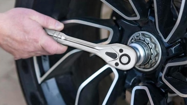man using hand tool on tire