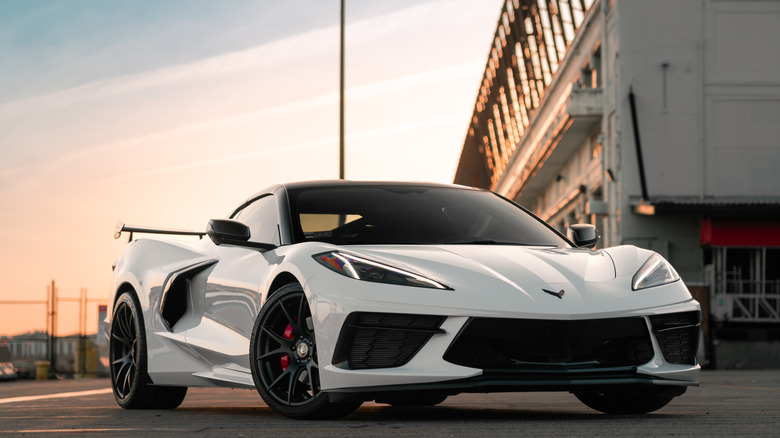 A white C8 Corvette parked in a parking lot for display