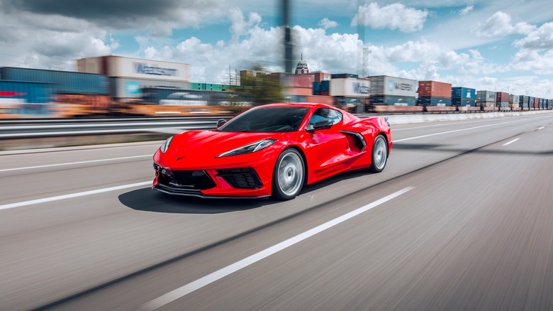 A red C8 Corvette speeding on a highway