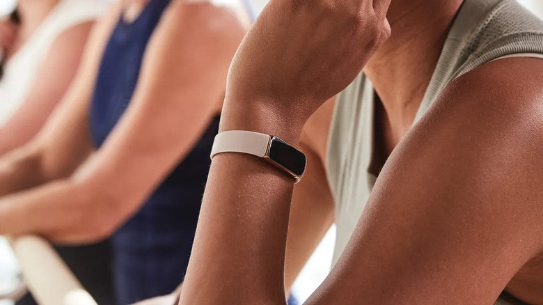 a woman is seen with the fitbit luxe on her wrist