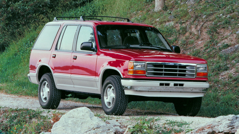 Front 3/4 view of red 1991 Ford Explorer on mountain trail.