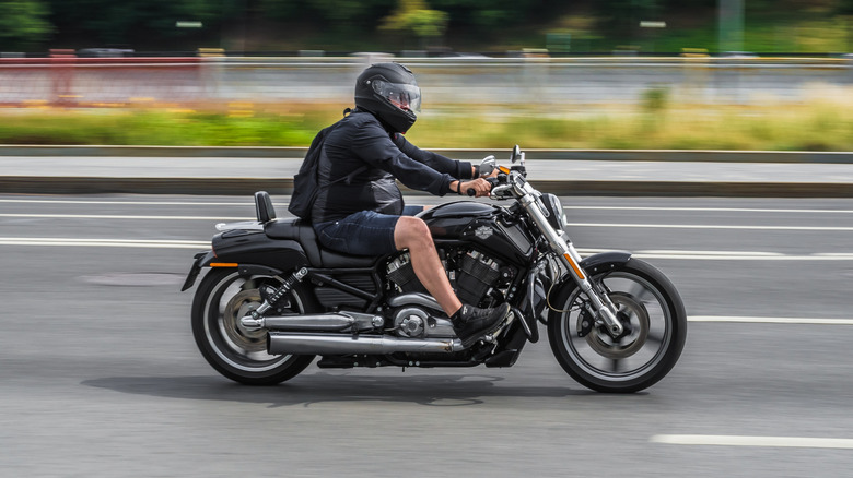 A rider riding a Harley-Davidson V-Rod, side view