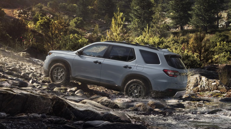 2025 Honda Pllot TrailSport in gray fording a stream, rear 3/4 view