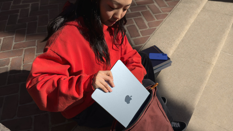 girl putting MacBook air into bag