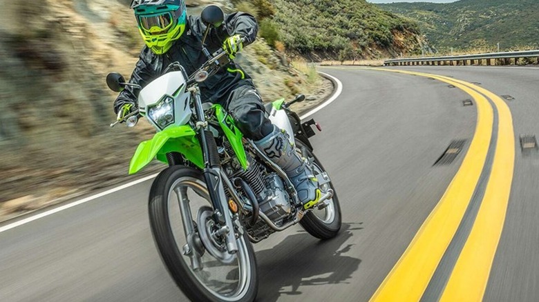 A Lime Green Kawasaki KLX230S on a paved mountain highway