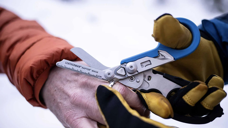 person cutting ring with leatherman raptor