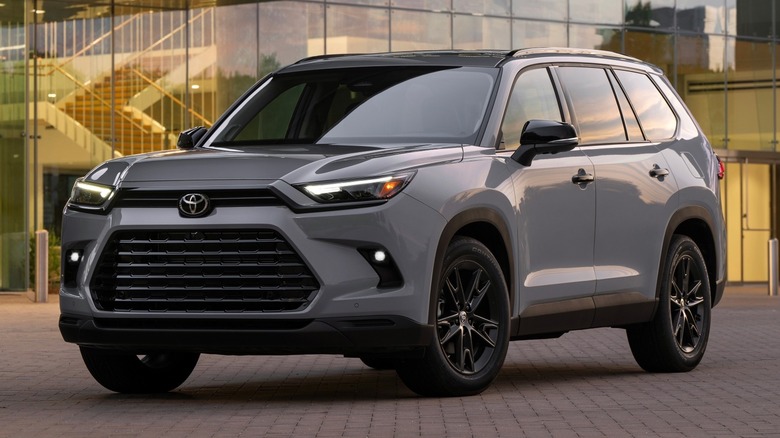 Toyota Grand Highlander Nightshade parked on a paved surface in front of a building