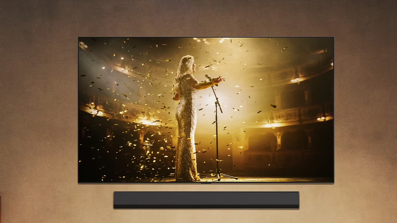 A wall-mounted LG G5 smart TV showing a performance.