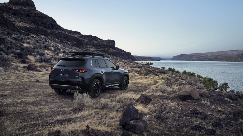 Rear 3/4 view of a gray Mazda CX-50 overlooking a coast line
