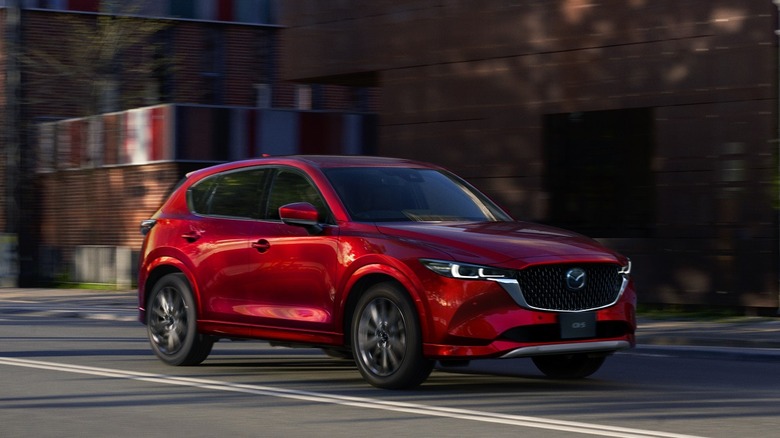 Red Mazda CX-5 driving down an urban street