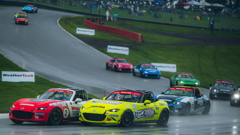 Mazda MX-5 Cup race cars on road course in the rain
