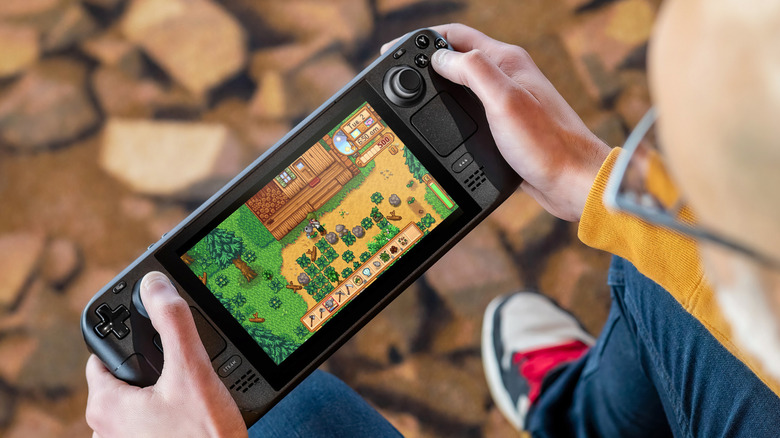 A gamer plays Stardew Valley outdoors on the Steam Deck
