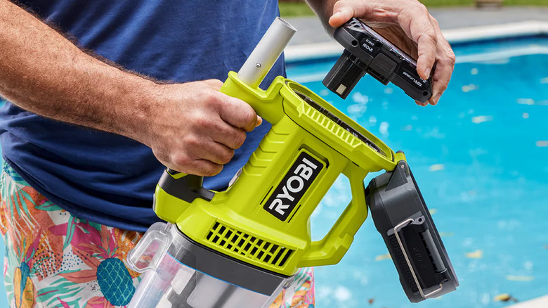 Man taking out battery from Ryobi Pool Vacuum