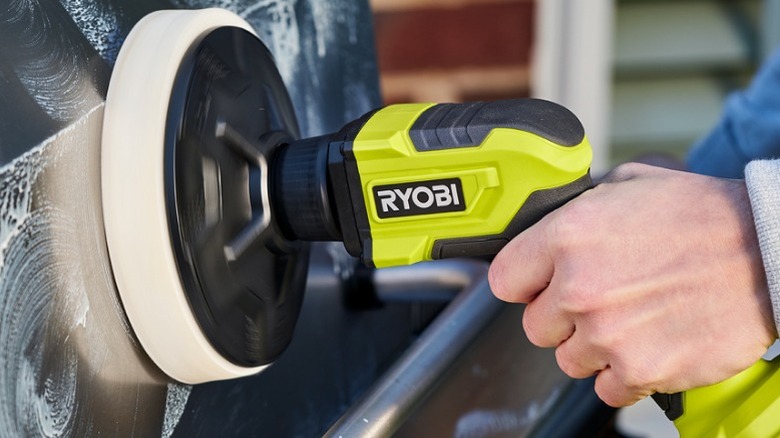 Person using Ryobi Power Scrubber to buff car
