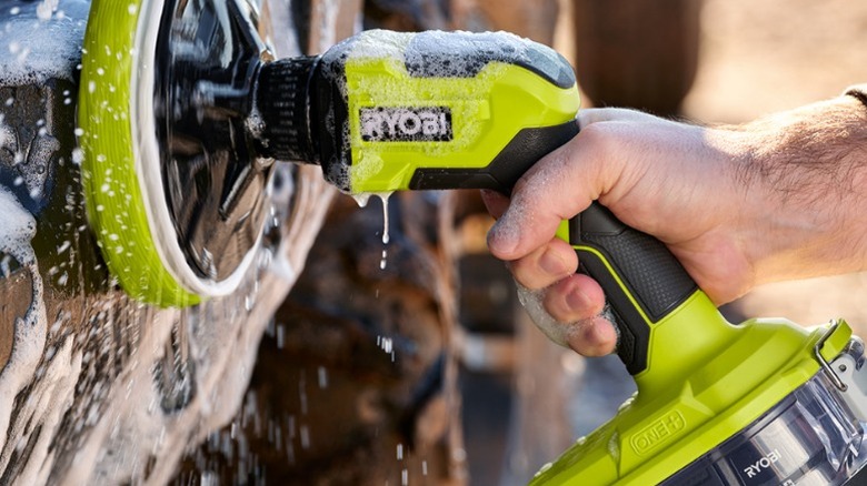 Person using Ryobi Power Scrubber on car