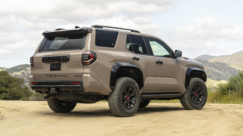 Rear 3/4 view of a dark beige Toyota 4Runner on a sandy trail