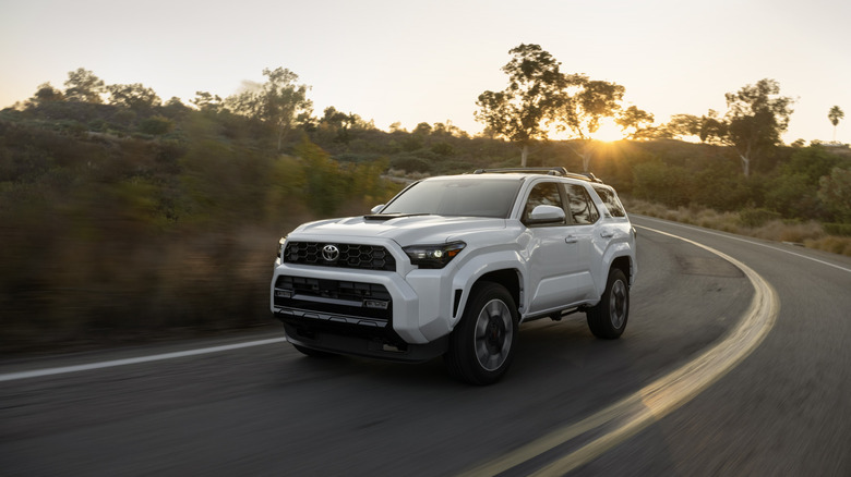 A white Toyota 4Runner on a twisty mountain road, front 3/4 view