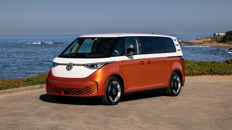 A Volkswagen ID. Buzz in white over looking over a coast, front 3/4 view